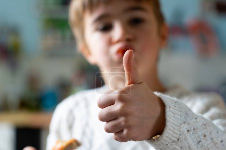 Photo for Boy with thumb up eating pizza - Royalty Free Image