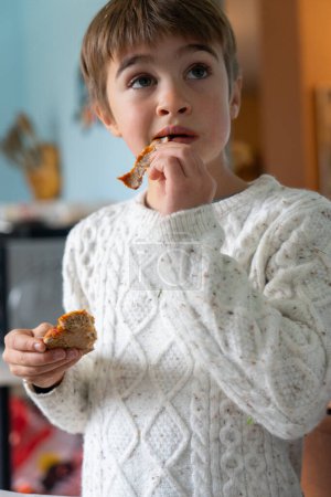 Téléchargez les photos : Boy eating a homemade pizza - en image libre de droit