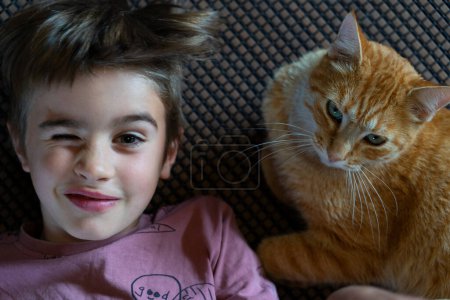 Boy winking with his cat