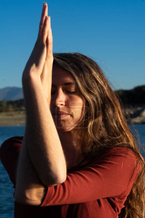 Woman meditating doing a yoga pose in nature