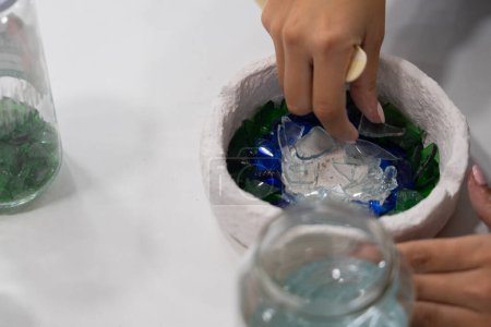 Frauenhände setzen Glas auf Keramik