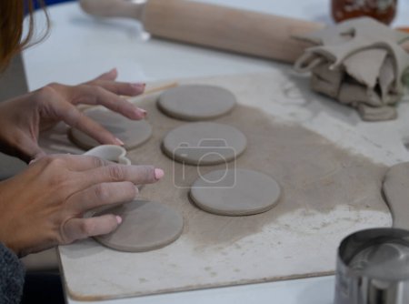 Mains de femme faisant de la poterie dans un atelier