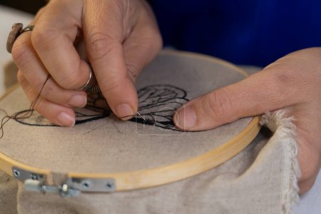 Woman's hands embroidering on an embroidery hoop