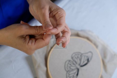 Woman spinning a thread for hand embroidery