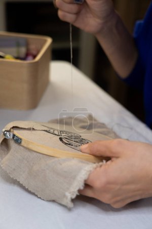 Hands of woman embroidering by hand seen up close