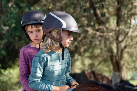 Zwei Kinder reiten gemeinsam auf Pferden