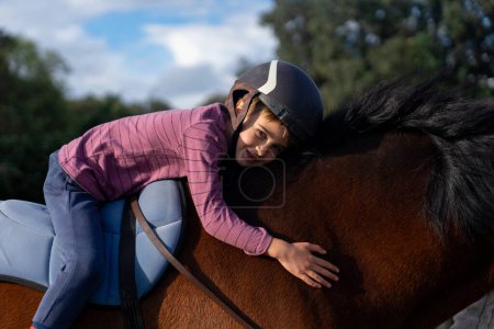 Ein Kind umarmt lächelnd ein Pferd
