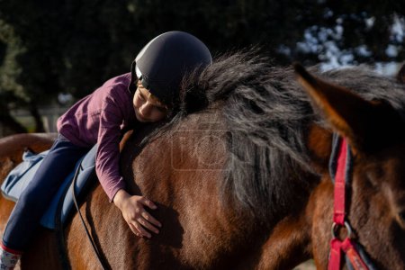 Ein Kind umarmt ein Pferd auf dem Rücken