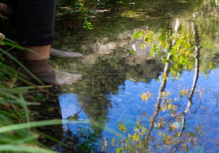 Les pieds de l'homme immergés dans l'eau d'une rivière