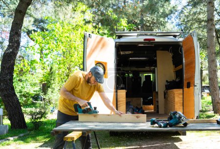 Man customizing his handcrafted camper van