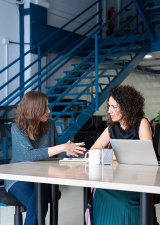 Dos mujeres emprendedoras en una reunión en un coworking