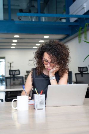 Mujer trabajando con un portátil en un coworking