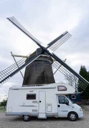 Téléchargez les photos : Camping-car avec un moulin traditionnel derrière aux Pays-Bas - en image libre de droit
