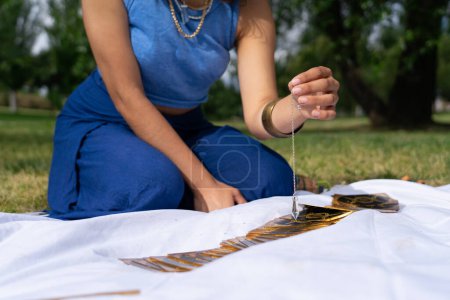 Woman with a pendulum reading tarot cards outdoors
