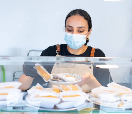 Mujer marroquí trabajando en su pequeño negocio de dulces marroquíes