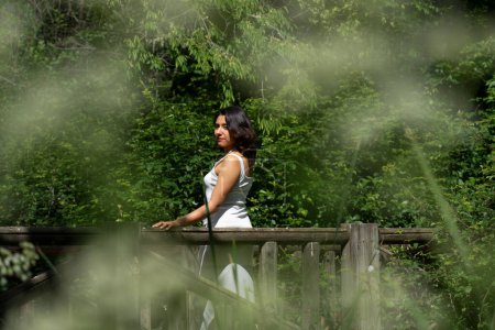Latin woman taking a walk in nature in a white dress. Mindfulness in nature