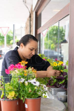 Marokkanerin schmückt den Eingang ihres kleinen lokalen Geschäfts mit Pflanzen und Blumen
