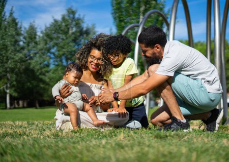 Lateinische Familie mit Kind und Baby sitzt zusammen in einem Park