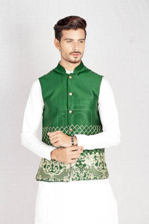 Téléchargez les photos : Homme traditionnel indien en chemise verte, fond blanc avec des vêtements traditionnels - en image libre de droit