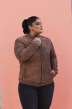 Téléchargez les photos : Une femme vêtue d'une veste brune et pantalon noir - en image libre de droit