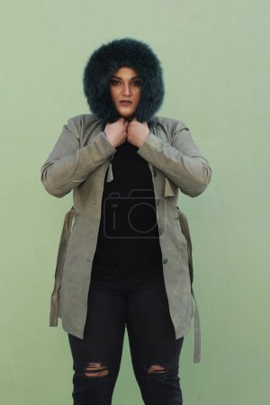 Téléchargez les photos : Une femme en chapeau de fourrure avec un long manteau vert et un pantalon noir - en image libre de droit