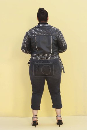 Téléchargez les photos : Une femme vêtue d'une veste noire et un jean - en image libre de droit