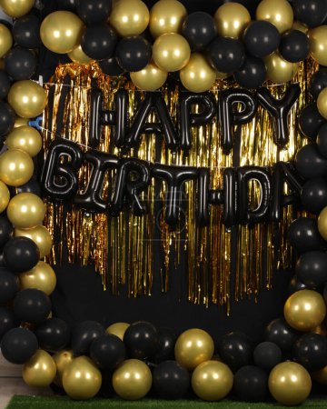 Hermoso fondo de feliz cumpleaños decorado con globos de oro y negro para fines fotográficos 