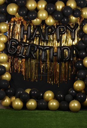 Beautiful decorated happy birthday background with gold and black balloons for photography purposes 