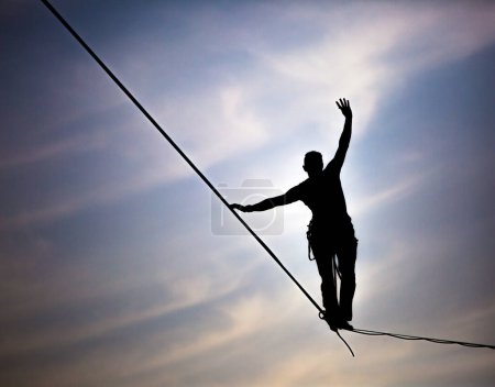 Téléchargez les photos : Slackliner équilibrage sur corde serrée contre le ciel - en image libre de droit