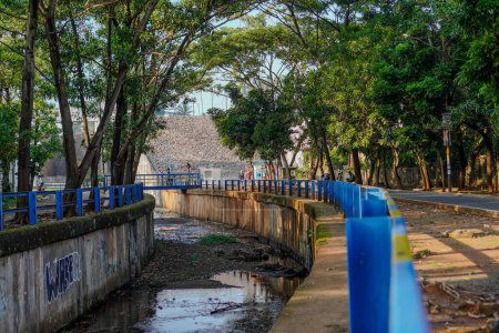 Téléchargez les photos : East Ciputat, South Tangerang, 19 décembre 2023 - Vue rapprochée de la clôture en fer qui sépare la rivière de la route qui longe la clôture - en image libre de droit