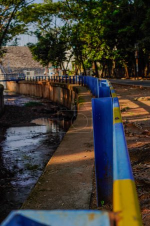 Téléchargez les photos : East Ciputat, South Tangerang, 19 décembre 2023 - Vue rapprochée de la clôture en fer qui sépare la rivière de la route qui longe la clôture - en image libre de droit