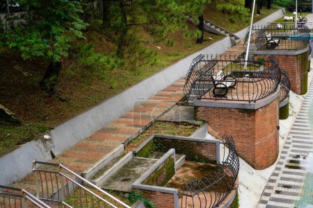 steps leading to the river with a footpath and iron guardrail, photo seen from above.