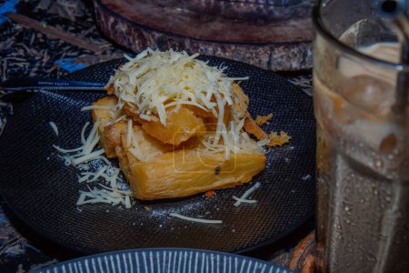 close-up view of fried cassava with a sprinkling of grated cheese.