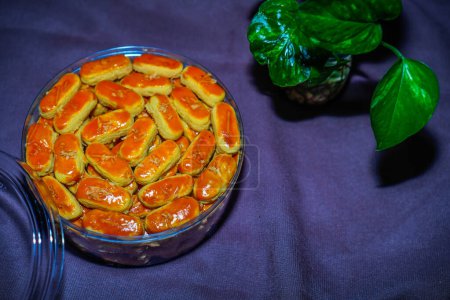 Close-up view of Kastengel cake with cheese sprinkles, neatly arranged in a jar.