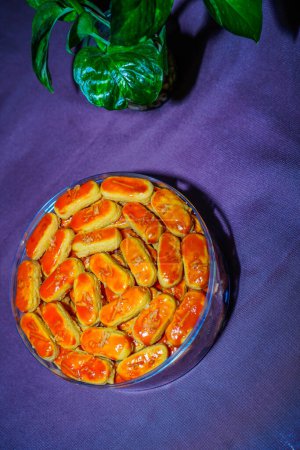Close-up view of Kastengel cake with cheese sprinkles, neatly arranged in a jar.