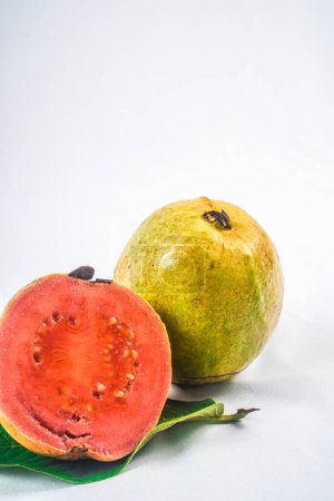 Guave isoliert. Sammlung von rotfleischigen Guaven mit gelbgrüner Schale auf einem Blatt isoliert auf weißem Hintergrund.