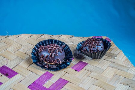 Vereinzelte Schokoladenknödel, Nahaufnahme von mit Streusel bestreuten Schokoladenknödeln, mit geflochtenem Bambus als Unterlage. Eid-Essen-Konzept.