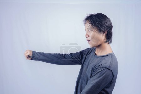 Foto de Guapo asiático hombre es excitado con completo fuerza gritando y revisión, en aislado blanco fondo para copia espacio. - Imagen libre de derechos