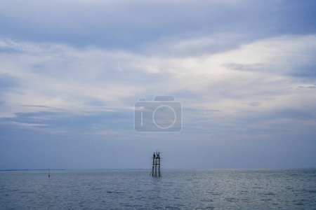 mira lejos de donde los pescadores capturan peces (branjang) en medio del mar contra un cielo brillante con espacio vacío para la publicidad.