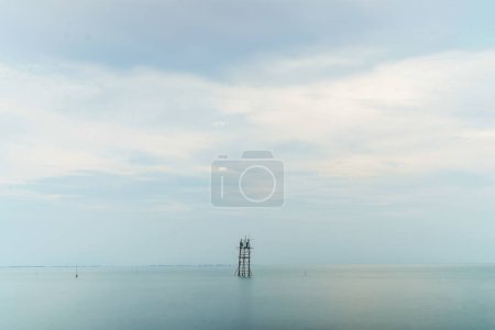 mira lejos de donde los pescadores capturan peces (branjang) en medio del mar contra un cielo brillante con espacio vacío para la publicidad.