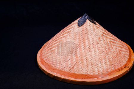 hat with woven bamboo, black background with empty space for advertising.