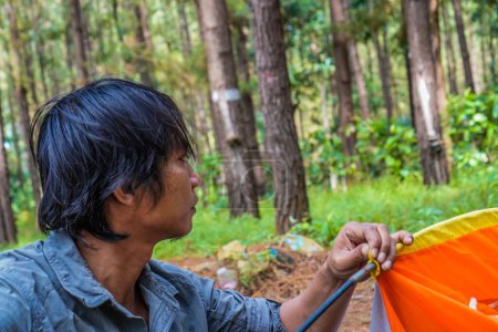 Javaner baut ein Zelt in einem Gummiwald auf, das Konzept der Erholung im Wald