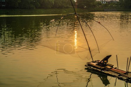 branjang als Ausrüstung für den Fang von Fischen im See, vor einem Sonnenuntergang Hintergrund mit leeren Himmel Raum für Werbung.