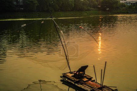 branjang como equipo para la captura de peces en el lago, situado sobre un fondo de puesta de sol con espacio en el cielo vacío para la publicidad.