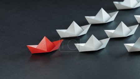 Foto de Barcos de papel y el concepto de liderazgo. barco de papel en negro. - Imagen libre de derechos