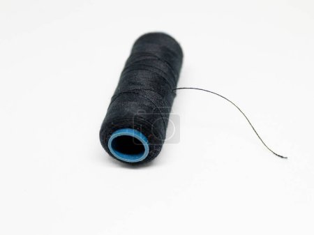 Spool of black and white thread, isolated white photo