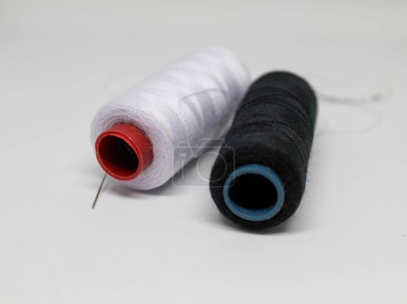 Spool of black and white thread, isolated white photo