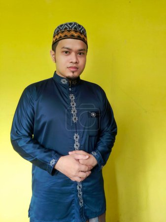 Asian man with cap and Muslim koko shirt
