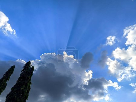 The blue sky with sunlight is covered by clouds