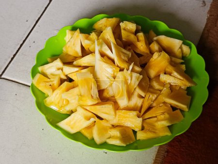 Sliced pineapple in a green plate